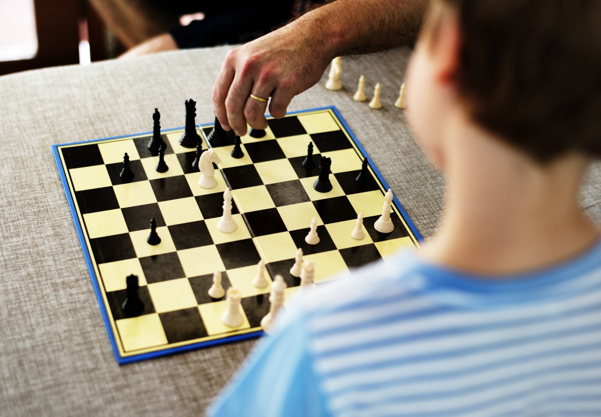 Rear view of young caucasian boy with chess boardgame
