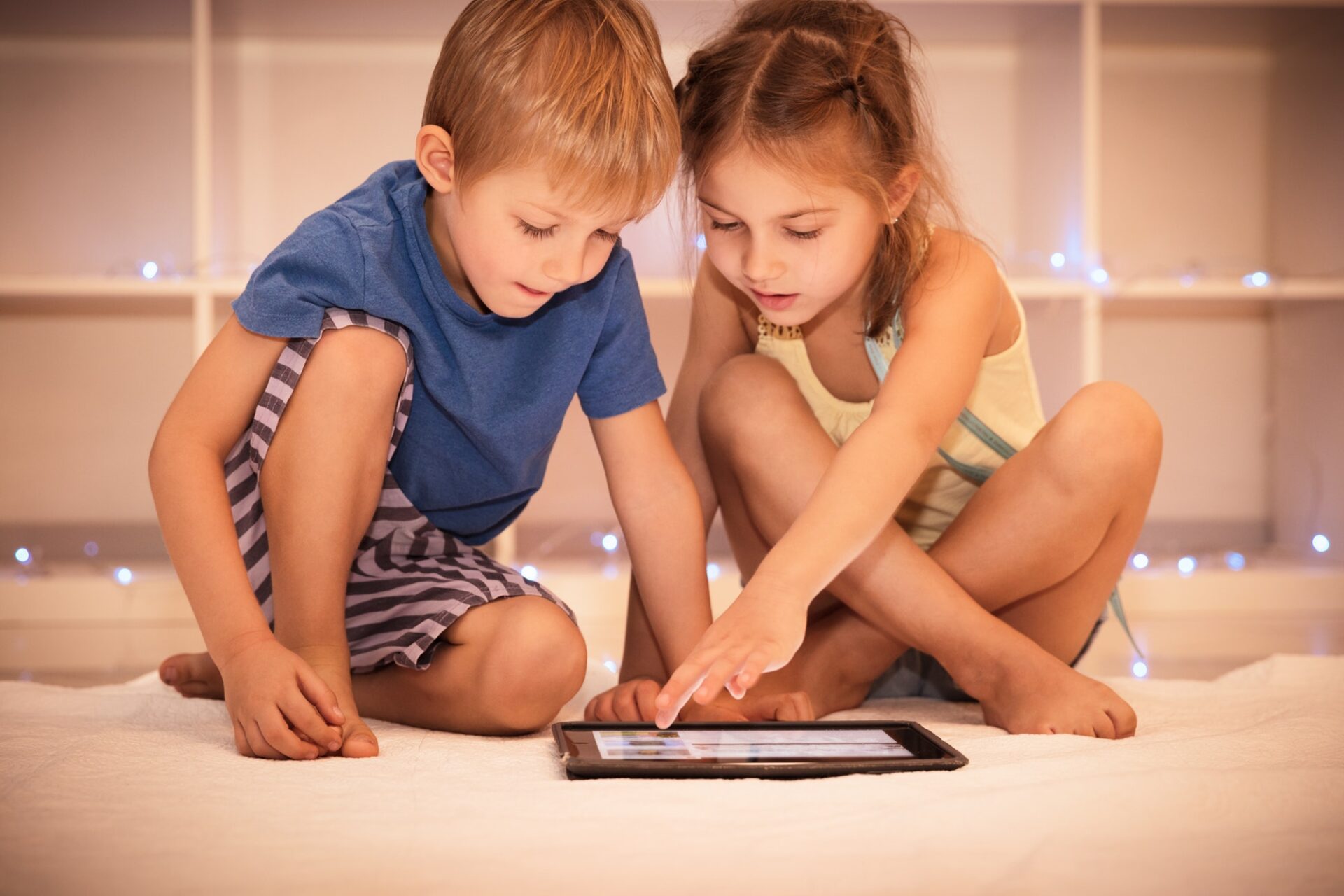 Two happy children playing on the tablet